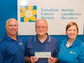 Taylor Bertelink/For The Intelligencer
Peter Heryet proudly holds a cheque, making him the recipient of $50,000. Doug Kane (left) and Jessica Klein (right) from the Canadian Cancer Society presented the check at 10 a.m. on Thursday morning in Belleville.