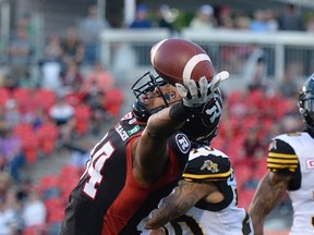 Ottawa Redblacks' Tori Gurley watches the ball bounce out of his hands in the end zone as Hamilton Tiger-Cats' Jay Langa looks on during the first half of a pre-season CFL game in Ottawa on June 8, 2017. (THE CANADIAN PRESS/Justin Tang)