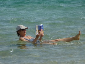 A woman reads a book while floating in the super-salty and super-buoyant water of the Dead Sea. ROBIN ROBINSON/TORONTO SUN