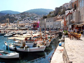 Travellers linger along Hydra's harbour, where humble boats and luxury yachts bob together in the stunningly blue water. (RICK STEVES PHOTO)