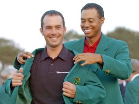 Golfing great Tiger Woods, right, helps Mike Weir don the traditional green jacket after the Southwestern Ontario native won the 2003 Masters at the Augusta National Golf Club in Augusta, Ga. (Canadian Press file photo)