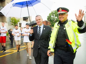 Matt Skof, president of the Ottawa Police Association and Ottawa Police Chief Charles Bordeleau make their way along the parade route during the Capital Pride's 2016 parade on Aug. 21, 2016.