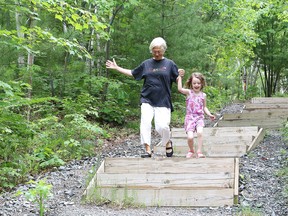 Ursula Sauve, president of Rainbow Routes Association, walks down stairs at the Lake Laurentian Conservation Area with her granddaughter, Lucina Sauve, 5, following a federal government funding announcement at the conservation area in Sudbury, Ont. on Friday June 16, 2017. John Lappa/Sudbury Star/Postmedia Network