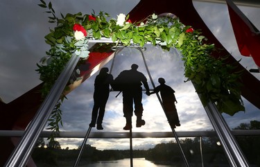 A piece of artwork depicting a military family is shown against a rising sun and the Bow River during the third annual Breakfast on the Bridge event  on Saturday June 17, 2017 in Calgary. The event takes place every two years, at sunrise, rain or shine, on the Peace Bridge and raises funds and awareness for the Calgary Military Family Resource Centre. Jim Wells//Postmedia
