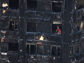 Urban Search and Rescue officers from London Fire Brigade inside the Grenfell Tower in west London after a fire engulfed the 24-storey building on Wednesday morning, Saturday, June 17, 2017.  (David Mirzoeff/PA via AP)