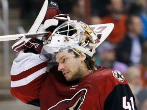 This March 22, 2016 photo shows Arizona Coyotes’ Mike Smith putting his mask back on as he skates back to his position in Glendale, Ariz. (AP Photo/Ross D. Franklin)