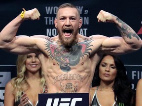 In this Nov. 11, 2016, file photo, Conor McGregor stands on a scale during the weigh-in event for his fight against Eddie Alvarez in UFC 205 mixed martial arts at Madison Square Garden in New York. (AP Photo/Julio Cortez, File)