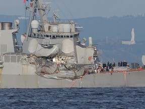 The damaged USS Fitzgerald is seen near the U.S. Naval base in Yokosuka, southwest of Tokyo, after the U.S. destroyer collided with the Philippine-registered container ship ACX Crystal in the waters off the Izu Peninsula Saturday, June 17, 2017. The USS Fitzgerald was back at its home port in Japan after colliding before dawn Saturday with the container ship four times its size, while the coast guard and Japanese and U.S. military searched for seven sailors missing after the crash. (AP Photo/Eugene Hoshiko)
