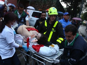 A woman is evacuated on a gurney after an explosion at the Centro Andino shopping center in Bogota, Colombia, Saturday, June 17, 2017. Authorities reported one woman was killed and 11 people injured. Authorities' attention immediately focused on the country's largest still active rebel group, the National Liberation Army, or ELN, which in February claimed responsibility for a bombing near Bogota's bullring that killed one police officer and injured 20 other people. (AP Photo/Ricardo Mazalan)