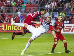 Toronto FC's Steven Beitashour  heads the ball against D.C. United during Saturday night's game at BMO Field. (ERNEST DOROSZUK/Toronto Sun)