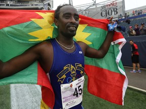 Manitoba Marathon winner Teresa Fekensa of Toronto celebrates with an Oromo flag at Investors Group Field in Winnipeg on Sun., June 18, 2017. Oromos are the largest ethnic group that live in Ethiopia and in East Africa, making up roughly one-third of Ethiopia’s population. Kevin King/Winnipeg Sun/Postmedia Network