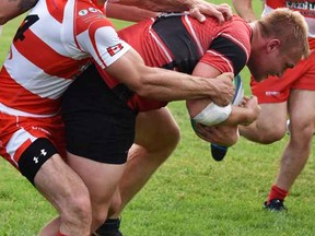 Belleville Bulldogs ballcarrier Chad Bain, just back from England and a stint in rugby league, gets wrapped up by a Vaughan Yeomen defender during TRU men's I action Saturday at MAS Park Field 1. (Chip McIntosh for The Intelligencer)