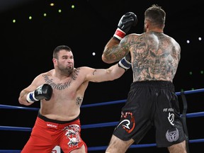 Tim Hague, shown here throwing a punch at opponent Adam Braidwood at Friday's fight at the Shaw Conference Centre, died in hospital Sunday. He was hopitalized after being knocked out in Friday's bout. (Ed Kaiser)