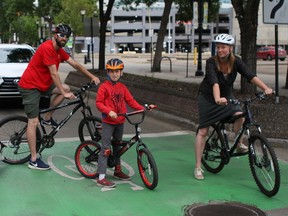 Derek Dallorto, pulling daughter Shana Lee Dallorto, 4, in a bike trailer, Beckett Lee Dallorto, 7, and Kristy Lee navigate a bike box along 100 Avenue on Sunday, June 18, 2017, in Edmonton, Alta. CLAIRE THEOBALD Postmedia