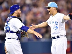 Blue Jays closer Roberto Osuna (right) and catcher Russell Martin celebrate yesterday’s win. Getty Images