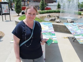 Andrea Lane prepares to contribute her forest-themed four-inch tile to Canada 150 Mosaic Mural Project's Sarnia mural, shown in the background. 
CARL HNATYSHYN/SARNIA THIS WEEK