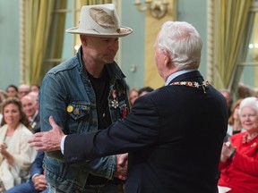 Governor General David Johnston shakes hands with Tragically Hip singer Gord Downie after investing him in the Order of Canada during a ceremony at Rideau Hall, Monday, June 19, 2017 in Ottawa. THE CANADIAN PRESS/Adrian Wyld
