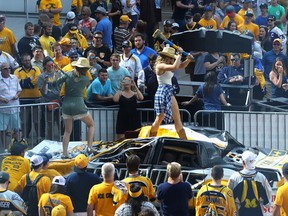 A Nashville Predators fan hits a Pittsburgh Penguins car with a sledgehammer prior to Game 3 of the Stanley Cup Final at the Bridgestone Arena on June 3, 2017. (Bruce Bennett/Getty Images)