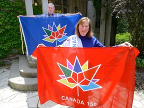 Judy Spooner and her husband, Neil, say colourful Canada 150 flags are brisk sellers at their New Century Flags shop on Commissioners Road in London. (MORRIS LAMONT, The London Free Press)