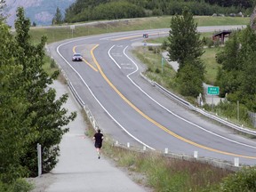 A jogger runs across the Sterling Highway from the Bird Creek access point, near a trail head that's closed on Monday, June 19, 2017, after a fatal bear mauling at Bird Ridge Trail in Anchorage, Alaska. Authorities say a black bear killed a 16-year-old runner while he was competing in an Alaska race on Sunday. (AP Photo/Mark Thiessen)