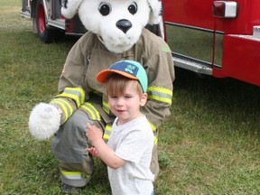 Jack and Sparky of the Central Huron Fire Department get acquainted at annual children's literacy "Touch-the-Truck" event