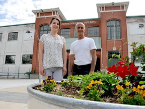 Julie Michaud, a parks project co-ordinator with the City of London (left), and Frank Filice, a member of the Old East Village Community Association, stop near one of the new gardens in Queen’s Park. CHRIS MONTANINI\LONDONER\POSTMEDIA NETWORK