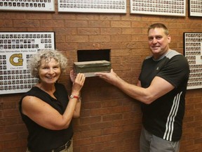 Tim Hunter (R) and Ruth Elias, both teachers at Glashan, hold the time capsule where it was found in the school. JEAN LEVAC