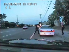 In this image made from July 6, 2016, video captured by a camera in the squad car of St. Anthony Police officer Jeronimo Yanez, the Minnesota police officer shoots at Philando Castile in the vehicle during a traffic stop in Falcon Heights, Minn. Yanez's backup officer Joseph Kauser is seen standing on the passenger side of the vehicle.  (St. Anthony Police department via AP)