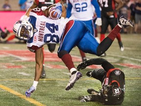 Receiver George Johnson of the Alouettes hangs on to the ball as he is upended by Ottawa Redblacks? Douglas Moss during a CFL preseason game in Montreal last week. A strong camp and exhibition games earned Johnson, a former Western Mustang from London, a spot on the Als active roster.  (The Canadian Press)