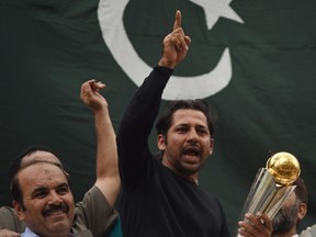 Pakistani cricket captain Sarfaraz Ahmed acknowledges fans as he holds the Champions Trophy in Karachi on Tuesday. (Getty Images)