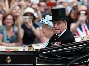 In this Saturday, June 17, 2017 file photo, Queen Elizabeth II and Prince Philip return to Buckingham Palace in a carriage, after attending the annual Trooping the Colour Ceremony in London. Buckingham Palace said on Wednesday June 21, 2017, Prince Philip is good spirits after being admitted to hospital. (AP Photo/Kirsty Wigglesworth, File)