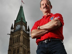Back to Earth after commanding the International Space Station, Sarnia-born Chris Hadfield ? who became a rock star astronaut with his tweets, music and photos from space ? is framed by the Peace Tower in Ottawa a day before his Canada Day 2013 performance on Parliament Hill. (Postmedia News file photo)