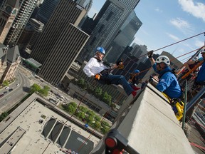 Columnist Dr. W. Gifford-Jones repels from the top of Toronto's City Hall on a rope as part of the Rope for Hope initiative. (Gordon Cheong Photo)