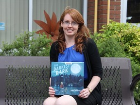 Strathroy Public Library branch supervisor Jean Moir holds a copy of The Darkest Dark by Chris Hadfield at the library’s reading garden. The book is one the top picks made by staff this summer for children to read. JONATHAN JUHA/STRATHROY AGE DISPATCH/POSTMEDIA NEWS