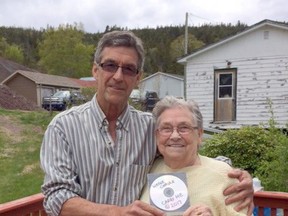 Wayne Chaulk of Buddy Wasisname and the Other Fellers presents Eleanor Parrott with a copy of his band's song "Carry Me," in a handout photo.  THE CANADIAN PRESS/HO-Wayne Chaulk