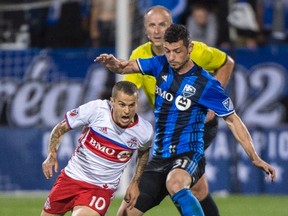 Toronto FC forward Sebastian Giovinco (left) and Impact’s Blerim Dzemaili battle for the ball during second half of the first leg of the Canadian Championship in Montreal last night. (Paul Chiasson/THE CANADIAN PRESS)