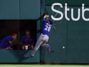 Blue Jays left fielder Steve Pearce hit the wall while chasing a Rangers’ inside-the-park home run in Arlington, Texas last night. He left the game with a bruised knee. (The Associated Press)