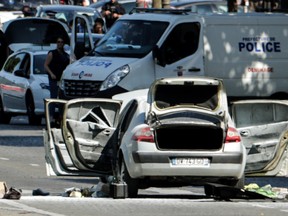 A car with all doors and trunk opened is pictured in a Police sealed off area of the Champs-Elysees avenue in Paris, on June 19, 2017, after a car crashed into a police van before bursting into flames, with the driver being armed, probe sources said. (Thomas Samson/AFP/Getty Images)