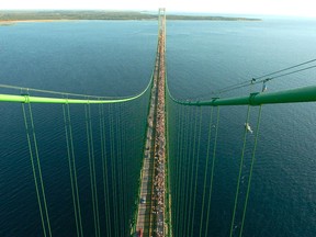 In this Sept. 5, 2005 file photo, thousands of people walk south from St. Ignace across the five-mile Mackinac Bridge during the 48th annual event on the span, which connect the Upper and Lower Peninsulas of Michigan. Michigan officials are questioning the safety of an Enbridge pipeline carrying oil beneath the waterway linking Lake Huron and Lake Michigan. The company says the two segments of the pipeline in the straits recently passed a pressure test. (AP Photo/John L. Russell)