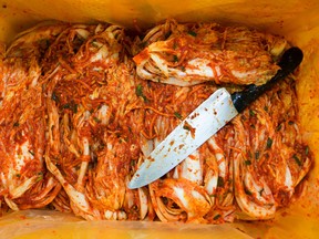 Seasoned kimchi and a knife sit inside a crate on the production line at the Ogawon Co. organic kimchi factory in Yangpyeong, South Korea, on Sept. 2, 2015. (SeongJoon Cho, Bloomberg)