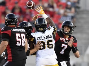 Ottawa Redblacks quarterback Trevor Harris throws the ball as Hamilton Tiger-Cats' Davon Coleman tries to block him, during the first half of a pre-season CFL game in Ottawa on June 8, 2017. (THE CANADIAN PRESS/Justin Tang)