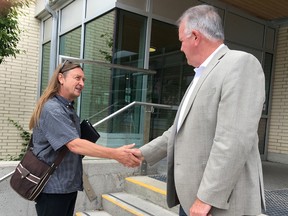 Ontario Labour Minister Kevin Flynn, right, greets Michael Harris, executive director of the KEYS Job Centre, at the Artillery Park Aquatic Centre on Thursday for a roundtable discussion on planned changes to workplace laws. (Elliot Ferguson/The Whig-Standard)