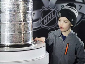 Ty Chabbert, 7, gave the Stanley Cup a close-up inspection when the NHL Centennial Fan Arena was in Ottawa. The Fan Arena will be coming to Tillsonburg August 10-12, and the Stanley Cup will be in town Friday, August 11 and Saturday, August 12. (Ashley Fraser/Postmedia Network)