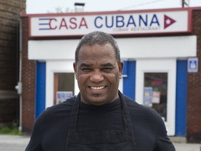 Juan Pedroso of Casa Cubana shows some of the food that will be featured at the International Food Festival. At left, is a dish called ropa vieja, featuring beef, beans and rice, fried plantain and salad. At right, is barbecued chicken, beans and rice, fried plantain and salad. (DEREK RUTTAN, The London Free Press)