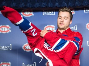 Newly acquired Montreal Canadien Jonathan Drouin puts on his jersey as he is introduced to the media during a press conference at the Bell Centre on June 15, 2017. (THE CANADIAN PRESS/Ryan Remiorz)