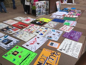 Signs demanding answers for missing and murdered indigenous women and girls, as well as men and boys, covered the steps of Edmonton City Hall before the Stolen Sisters and Brothers Awareness walk on June 11, 2017.