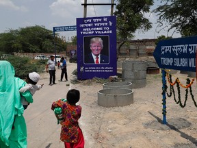 A photograph of U.S. President Donald Trump is displayed at the entrance of Trump Sulabh Village in Maroda, India, Friday, June 23, 2017. A toilet charity is leading an effort to rename a tiny, north Indian village after President Donald Trump, saying the gesture is meant to honor relations with the U.S. and draw support for better sanitation in India. (AP Photo/Tsering Topgyal)
