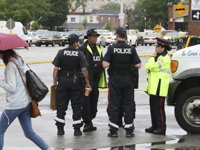 Toronto Police Services scour the parking lot of the Galleria Shopping Mall at Dupont and Dufferin Sts. after a 16-year-old was stabbed to death early this morning. A man and woman were arrested on Fri., June 23, 2017. (Stan Behal/Toronto Sun)