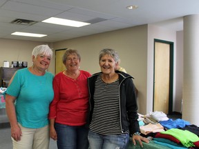 Photo by Jesse Cole Reporter/Examiner
Judi Lockhardt (right) joins fellow church members during St. Matthew’s Lutheran Church’s free ‘gift’ away event. Lockhardt and the rest of St. Matthews offered up hundreds of articles of donated clothing to the community as a way of saying thank you for all of the donations the church receives each year.