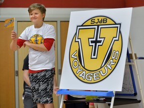 Sixth-grader Dylan Baker salutes Saint-Jean-de-Brebeuf?s new flag and logo. (MORRIS LAMONT, The London Free Pess)